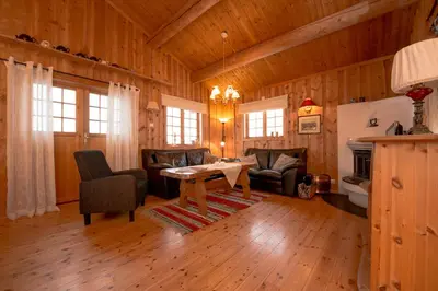 a living room with a table and chairs in a cabin at Festly in Ringsaker