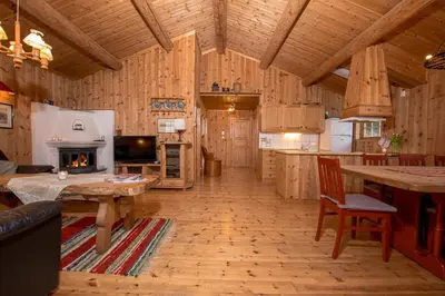 a large kitchen with wooden floors and a fireplace at Festly in Ringsaker