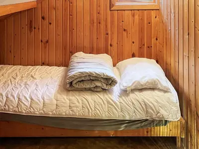 a bed in a wooden room with two pillows at 7 person holiday home in STRYN-By Traum in Stryn