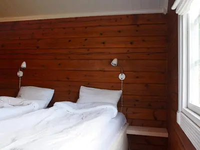 two beds in a room with a wooden wall at 4 person holiday home in Utvik-By Traum in Utvik