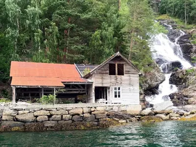 an old house on the shore of a waterfall at 4 person holiday home in Utvik-By Traum in Utvik