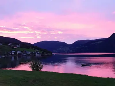 a boat on a lake with mountains in the background at 4 person holiday home in Utvik-By Traum in Utvik