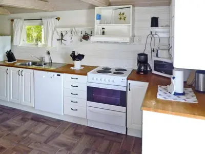a kitchen with white cabinets and a stove top oven at 6 person holiday home in TYSSE-By Traum in Tysse