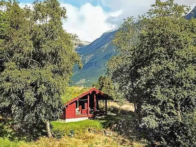 a small red cabin in the middle of trees at 6 person holiday home in olden in Olden