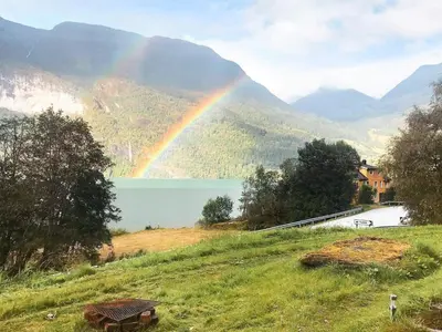 a rainbow over a lake with a bench in a field at 2 person holiday home in STRYN-By Traum in Stryn