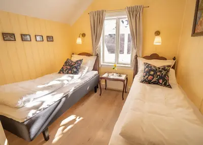 a small room with two beds and a window at Husum Hotel in Borgund