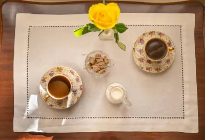 a table with two cups of coffee and a vase with a flower at Husum Hotel in Borgund