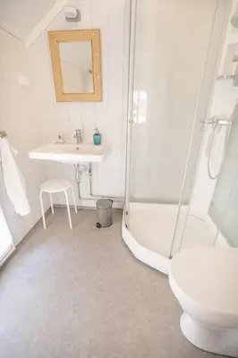 a white bathroom with a sink and a shower at Husum Hotel in Borgund