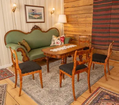 a living room with a couch and a table and chairs at Husum Hotel in Borgund