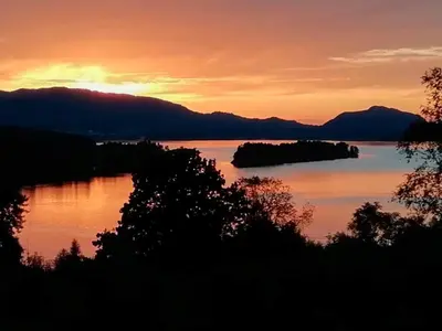 a sunset over a lake with islands in the water at 6 person holiday home in LONEVÅG-By Traum in Lonevåg