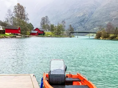 an orange boat on the water with a dock at 6 person holiday home in olden-By Traum in Olden