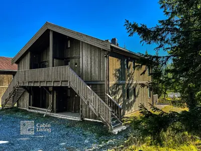 a large wooden building with a staircase in front at Modern ski-in out apartment at Sjusjøen in Sjusjøen