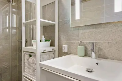 a white bathroom with a sink and a mirror at Modern ski-in out apartment at Sjusjøen in Sjusjøen