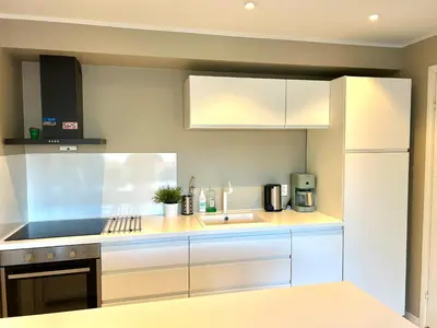 a kitchen with white cabinets and a sink at Havn i Etne with fjordview in Etnesjøen