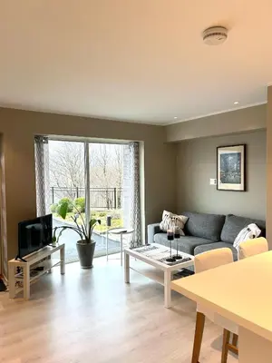 a living room with a couch and a tv at Havn i Etne with fjordview in Etnesjøen