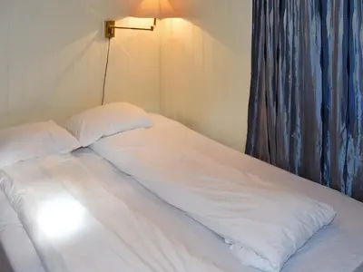 a bed with white sheets and pillows on it at 6 person holiday home in SANDANE-By Traum in Sandane