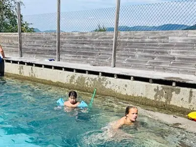 two children playing in a swimming pool in the water at 6 person holiday home in SANDANE-By Traum in Sandane