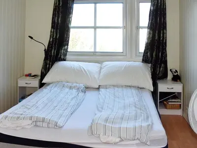 a bed with two pillows and a window at 6 person holiday home in SANDANE-By Traum in Sandane