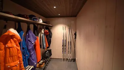 a walk in closet with ski equipment in it at Unique cabin with fantastic lake view, sauna, ski & EV outlet in Svingvoll