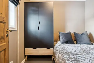 a bedroom with a black cabinet next to a bed at Nice apartment with Sauna and ski in out Trysil in Trysil