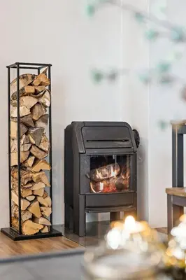a fireplace with a pile of logs next to it at Nice apartment with Sauna and ski in out Trysil in Trysil