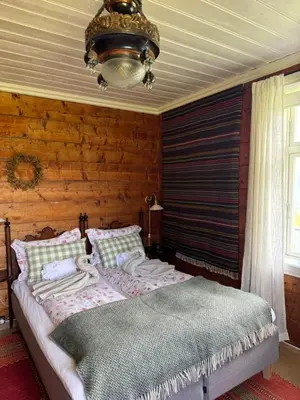 a bedroom with a bed and a chandelier at Eide Gardshotell in Skjolden