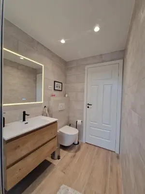 a bathroom with a sink and a toilet and a mirror at Cozy Retreat in the Heart of Ålesund in Ålesund