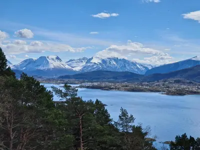a view of a lake with snow capped mountains at Cozy Retreat in the Heart of Ålesund in Ålesund