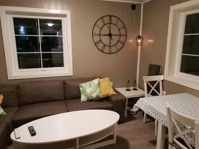 a living room with a couch and a clock on the wall at Havglimt in Oksvoll