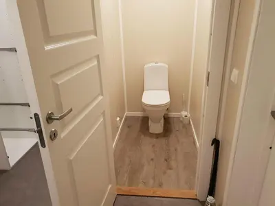 a small bathroom with a toilet and a door at Havglimt in Oksvoll