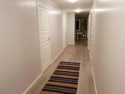 a hallway with white walls and a rug on the floor at Havglimt in Oksvoll