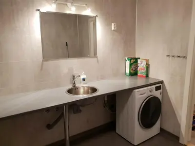 a bathroom with a sink and a washing machine at Havglimt in Oksvoll