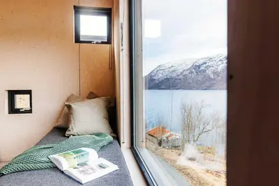 a bedroom with a window with a view of a mountain at Mikrohyttene i Åkrafjorden in Etnesjøen