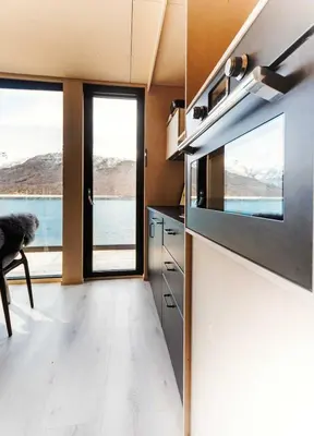 a kitchen with a view of the water and a window at Mikrohyttene i Åkrafjorden in Etnesjøen