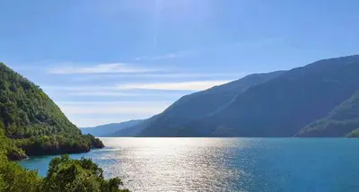 a large body of water with mountains in the background at Mikrohyttene i Åkrafjorden in Etnesjøen