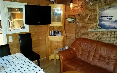 a living room with a leather couch and a television at Havgløtt in Oksvoll