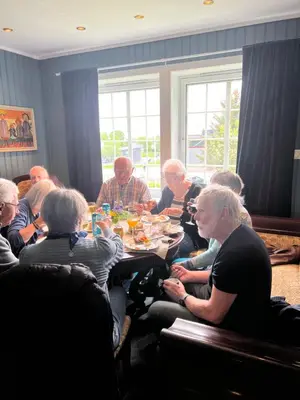 a group of people sitting around a table eating food at Sjarmerende hus med veldig stort uteareal. in Brekstad