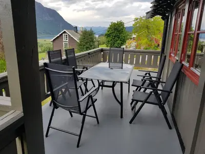 a patio with a table and chairs on a balcony at Hatlen View in Isfjorden