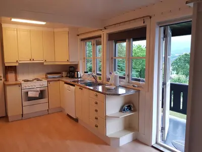 a kitchen with yellow cabinets and a large window at Hatlen View in Isfjorden