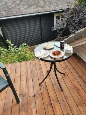 a table with two plates of food on a deck at Sjarmerende feriehus i Olden rett ved fjorden in Stryn
