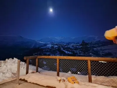 a snow covered balcony with the moon in the sky at Cabin in beautiful surroundings at Harpefossen in Nordfjordeid
