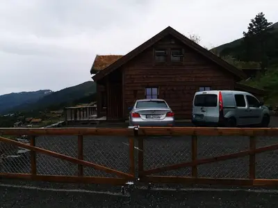 two cars parked in front of a house at Cabin in beautiful surroundings at Harpefossen in Nordfjordeid