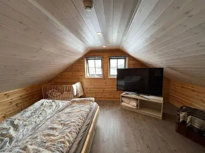 a bedroom with a bed and a flat screen tv at Cabin in beautiful surroundings at Harpefossen in Nordfjordeid