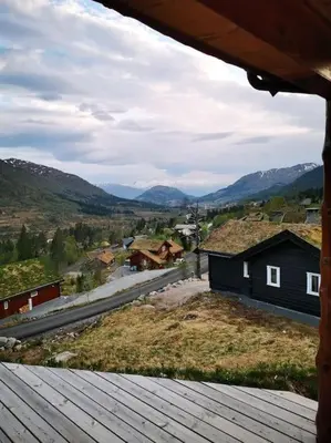 a view from the porch of a house with mountains in the background at Cabin in beautiful surroundings at Harpefossen in Nordfjordeid