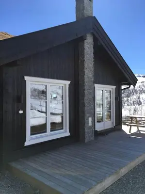 a building with two windows and a wooden deck at Holiday cottage with 4 bedroom on 145m² in Sogndal in Sogndal