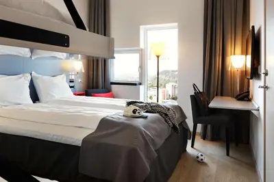 a hotel room with a bed and a desk at Scandic Lerkendal in Trondheim