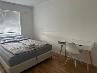 a bedroom with a bed and a desk and a chair at Ålesund Urban - Spacious and luminous 100 m2 urban flat with 3 large bedrooms in Ålesund