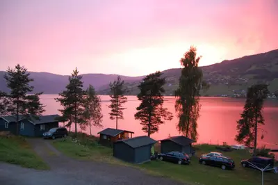 a view of a lake with a group of huts at Lyngmo Gjestehus in Hafslo