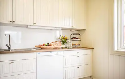 a kitchen with white cabinets and a bowl of food on a counter at Lovely Home In Hebnes With Wifi in Hebnes