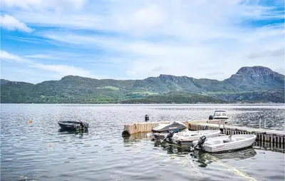 a group of boats parked at a dock on a lake at Lovely Apartment In Hebnes in Hebnes